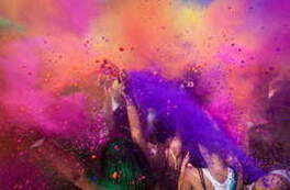 Grupa ludzi rozsypująca kredę w r&oacute;żnych kolorach